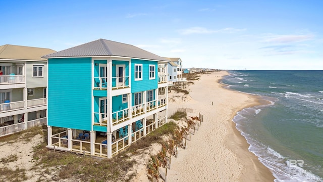 exterior space featuring a water view, a beach view, and driveway