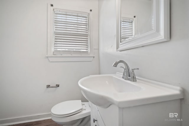 bathroom featuring vanity, hardwood / wood-style flooring, and toilet