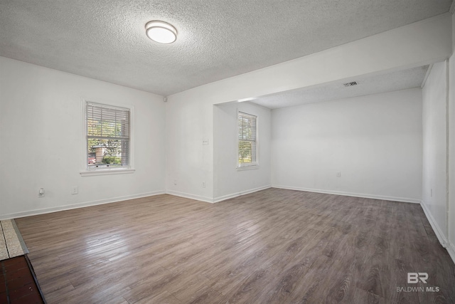 empty room featuring hardwood / wood-style flooring and a textured ceiling