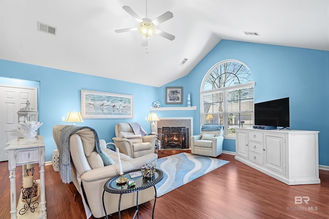 living room featuring a tiled fireplace, ceiling fan, dark hardwood / wood-style floors, and lofted ceiling