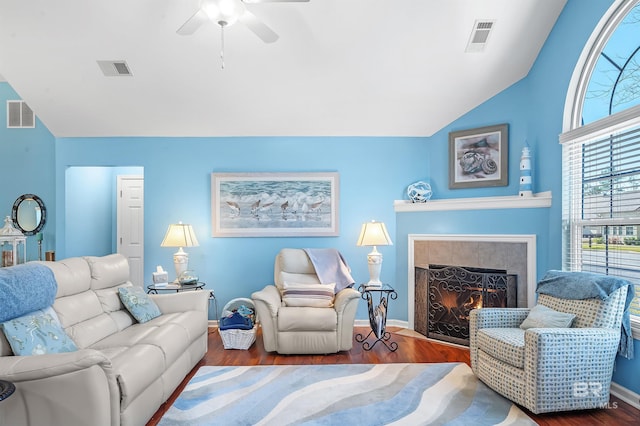 living room with ceiling fan, dark hardwood / wood-style flooring, a fireplace, and vaulted ceiling