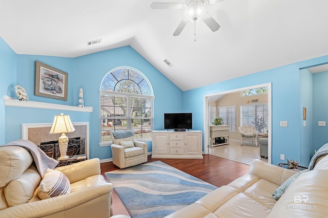 living room with ceiling fan, vaulted ceiling, and hardwood / wood-style flooring