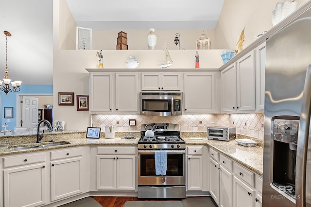 kitchen featuring sink, white cabinets, decorative light fixtures, and appliances with stainless steel finishes