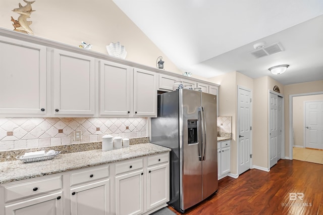 kitchen featuring backsplash, light stone counters, dark wood-type flooring, stainless steel fridge with ice dispenser, and white cabinetry