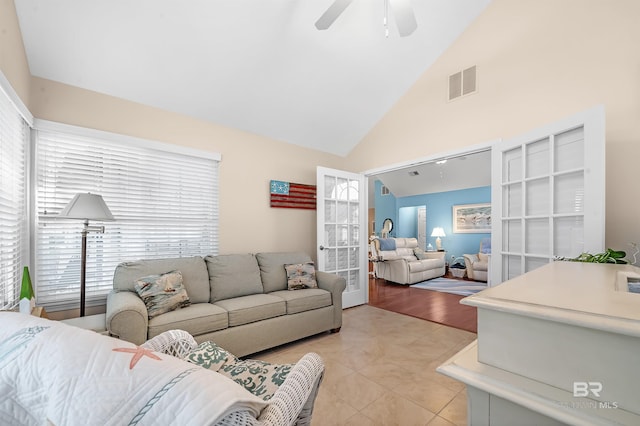 living room featuring ceiling fan, light tile patterned floors, and lofted ceiling