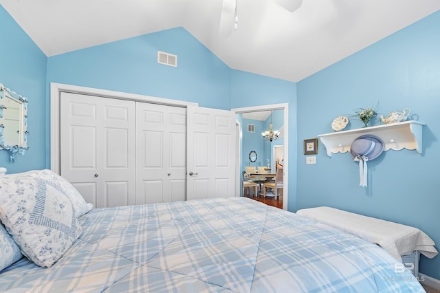 bedroom featuring ceiling fan with notable chandelier, vaulted ceiling, and a closet