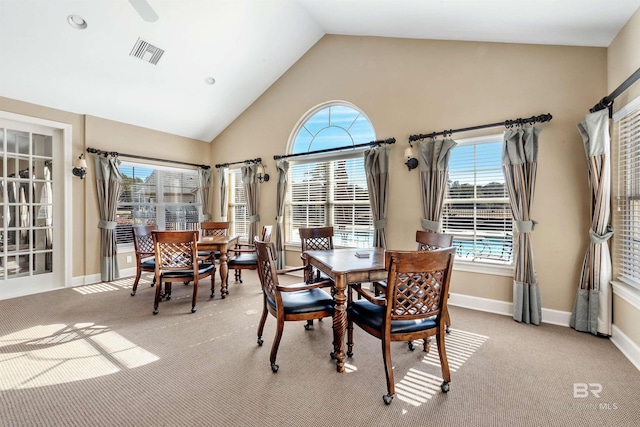 dining area with a wealth of natural light, light colored carpet, and vaulted ceiling