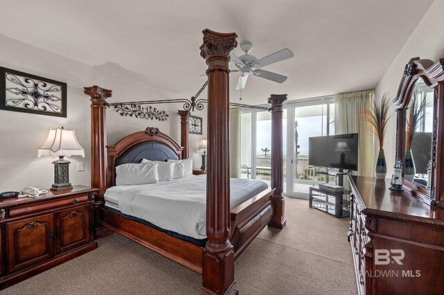 carpeted bedroom with multiple windows, a wall of windows, a ceiling fan, and access to outside