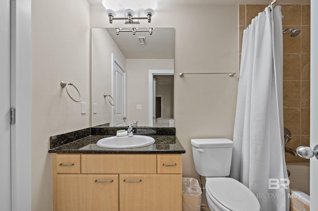 bathroom with vanity, toilet, tiled shower / bath, and visible vents