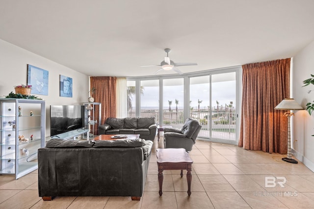 living area with light tile patterned floors, a wall of windows, and a ceiling fan