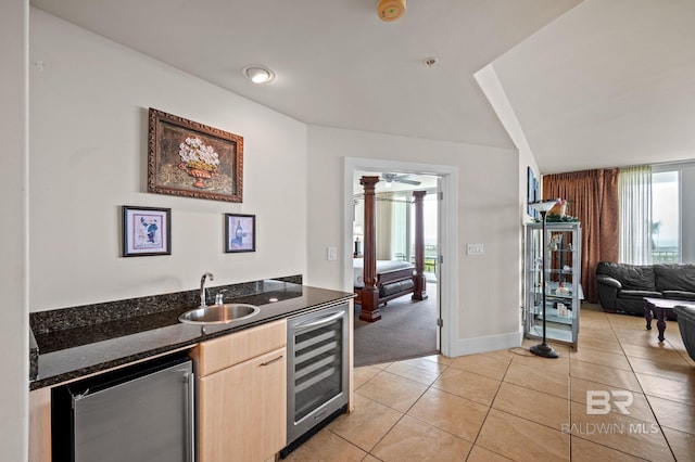 kitchen featuring wine cooler, light tile patterned floors, a wealth of natural light, and a sink