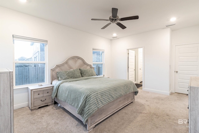 bedroom with connected bathroom, ceiling fan, and light colored carpet