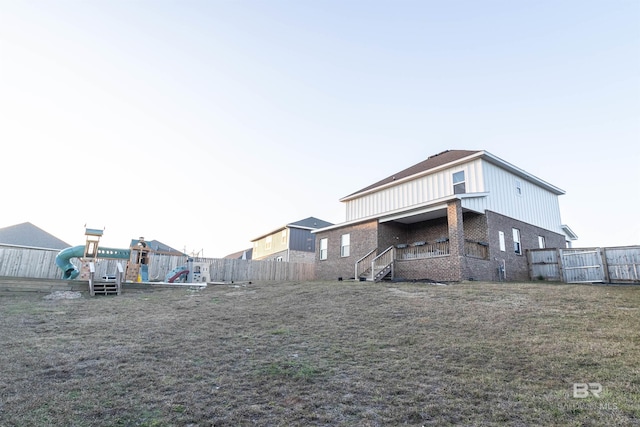 rear view of house featuring a playground