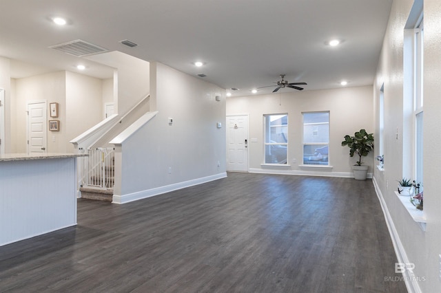 unfurnished living room with ceiling fan and dark wood-type flooring