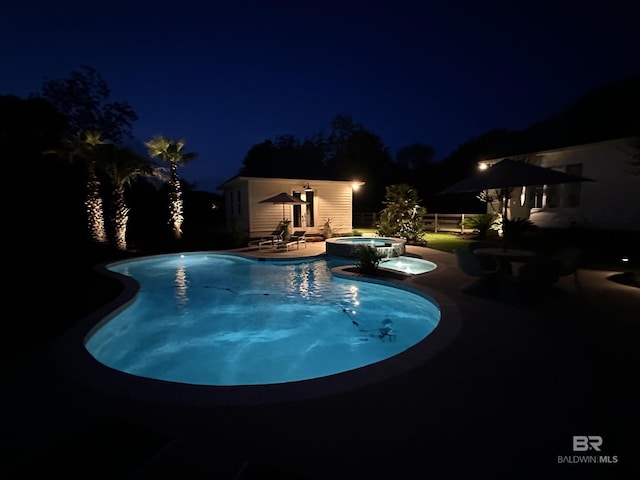 pool at twilight featuring a patio, an outdoor structure, and a pool with connected hot tub