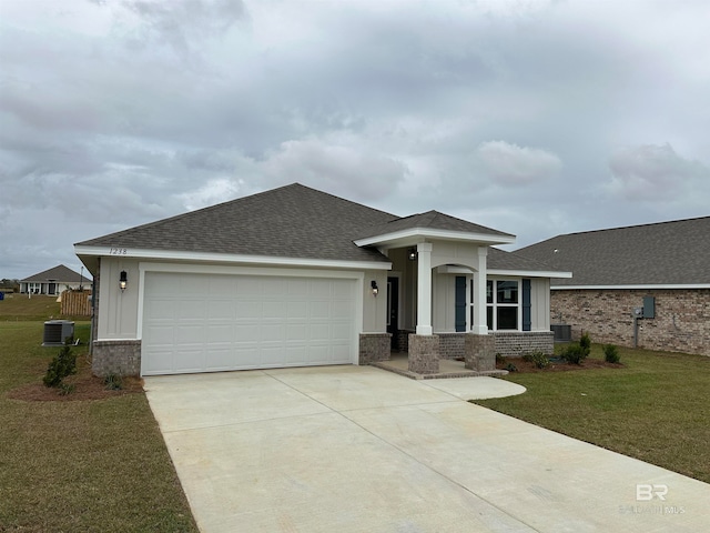 view of front facade with a front lawn, central AC unit, and a garage