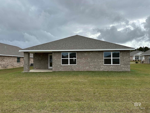 rear view of house featuring a yard and a patio area