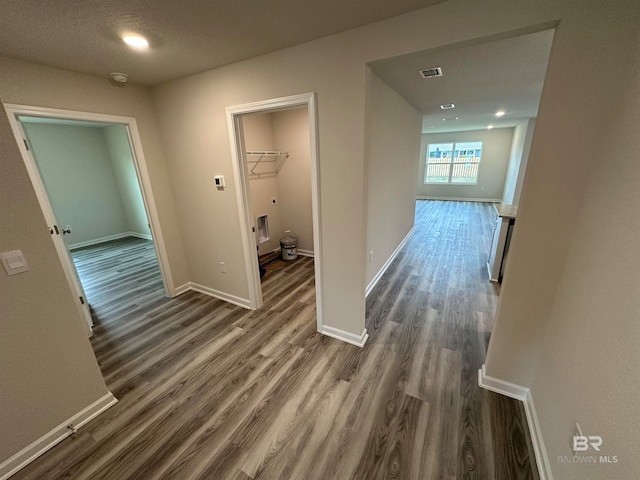 corridor with dark wood-type flooring and a textured ceiling