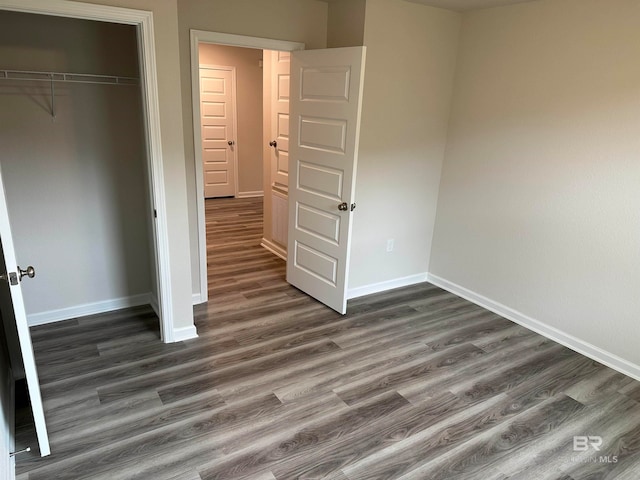 unfurnished bedroom featuring a closet and dark hardwood / wood-style floors