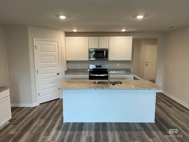 kitchen with white cabinets, dark hardwood / wood-style flooring, an island with sink, light stone countertops, and stainless steel appliances