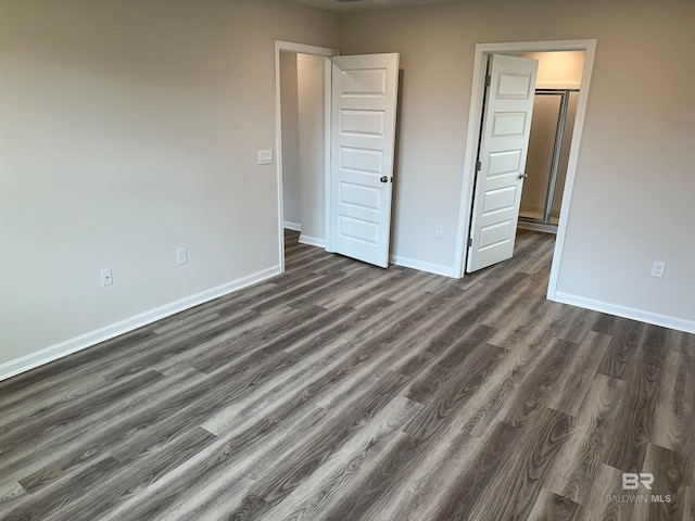 unfurnished bedroom with dark wood-type flooring