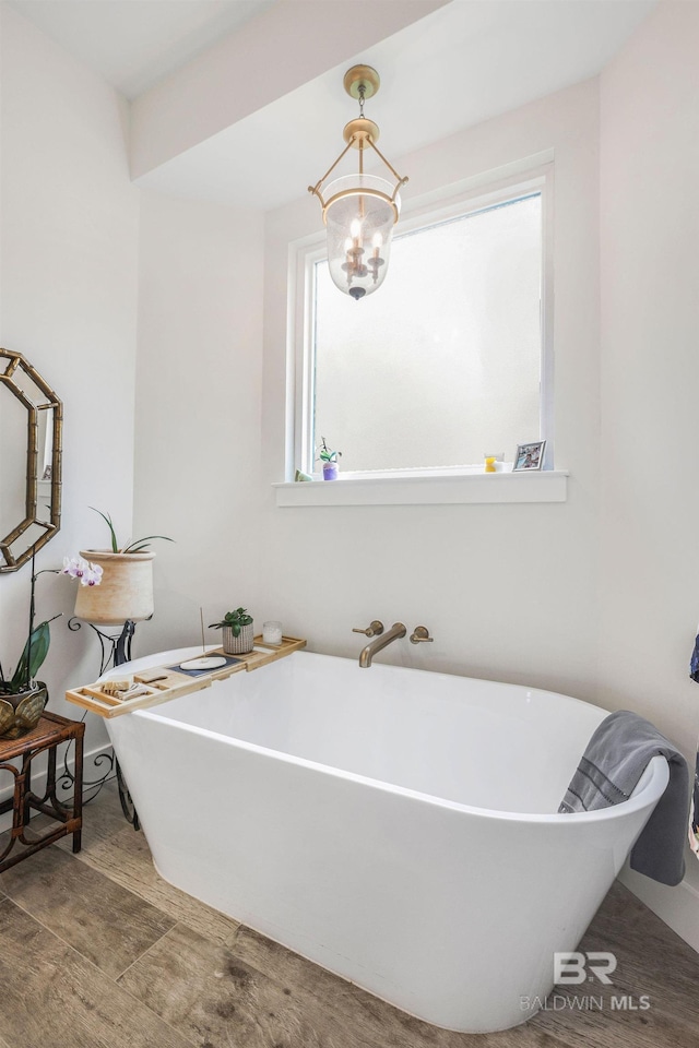 full bath with a chandelier and a soaking tub