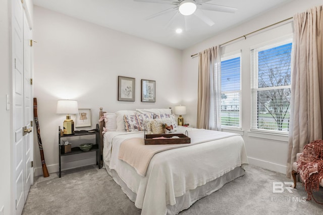 carpeted bedroom with ceiling fan and baseboards