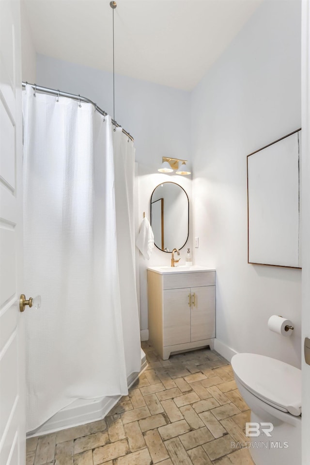 full bathroom featuring a shower with curtain, vanity, toilet, and baseboards