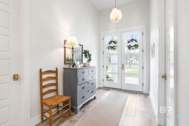 entrance foyer featuring light wood-type flooring, french doors, and baseboards