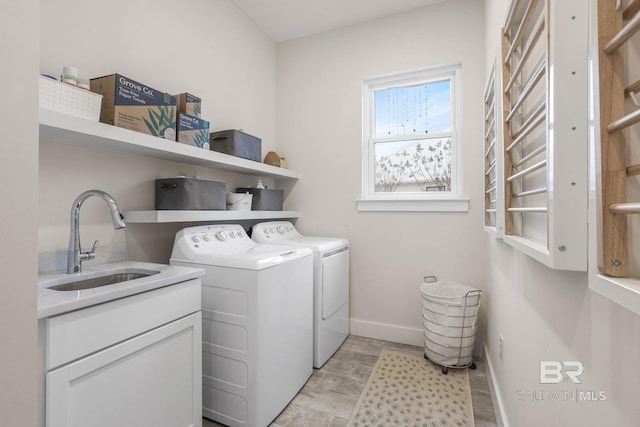 laundry room with cabinet space, a sink, washer and clothes dryer, and baseboards