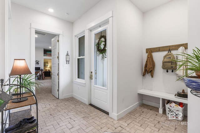 mudroom featuring brick floor, baseboards, a wealth of natural light, and recessed lighting