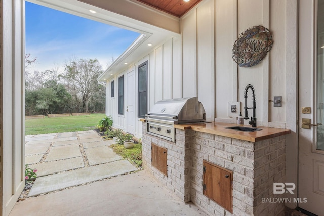 view of patio featuring exterior kitchen, a grill, and a sink