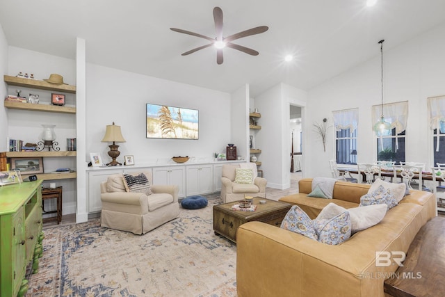 living area featuring vaulted ceiling and a ceiling fan