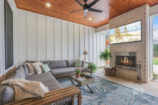 carpeted living area featuring an outdoor brick fireplace, wooden ceiling, recessed lighting, and a healthy amount of sunlight