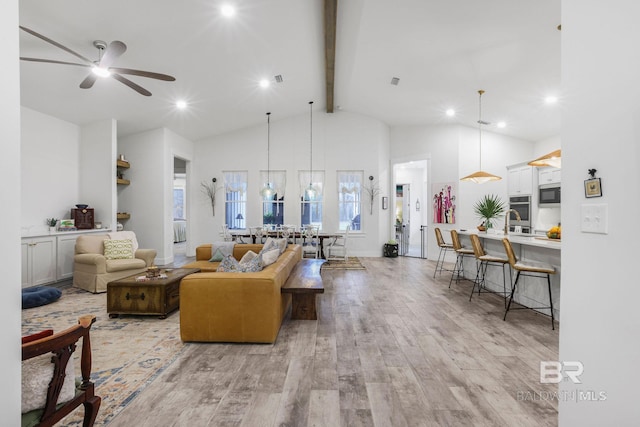 living area featuring light wood finished floors, a ceiling fan, high vaulted ceiling, beam ceiling, and recessed lighting