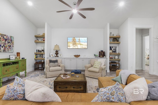 living area featuring lofted ceiling, a ceiling fan, and baseboards