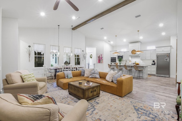 living area featuring vaulted ceiling with beams, recessed lighting, visible vents, a ceiling fan, and light wood-style floors