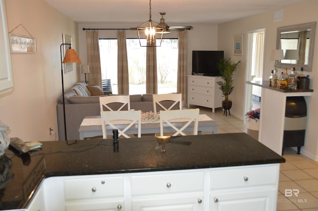 kitchen featuring open floor plan, visible vents, light tile patterned flooring, and white cabinetry