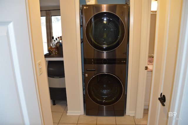 washroom featuring laundry area, tile patterned floors, and stacked washer / drying machine