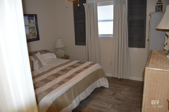 bedroom with baseboards and wood finished floors