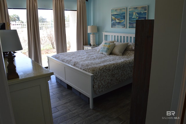 bedroom with access to outside, multiple windows, and wood finish floors