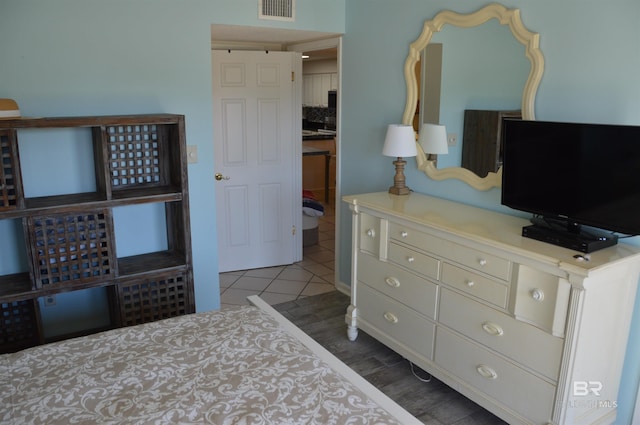 bedroom featuring visible vents and wood finished floors