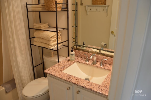 bathroom with a shower with shower curtain, vanity, and toilet