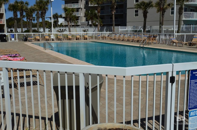 pool with fence and a patio