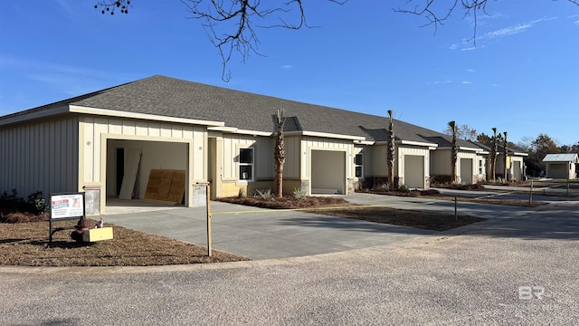 view of front facade featuring a garage, concrete driveway, roof with shingles, and board and batten siding