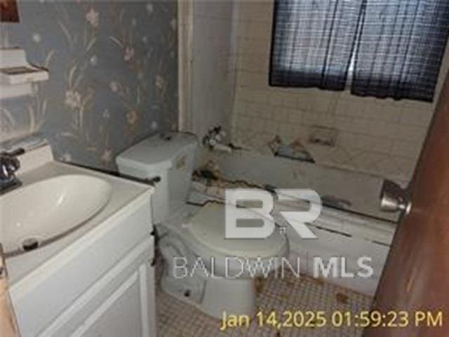 full bathroom with vanity, tiled shower / bath, and toilet