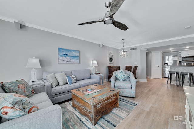 living room featuring light hardwood / wood-style flooring, ceiling fan, and crown molding