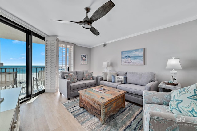 living room featuring floor to ceiling windows, ceiling fan, crown molding, a water view, and light hardwood / wood-style flooring