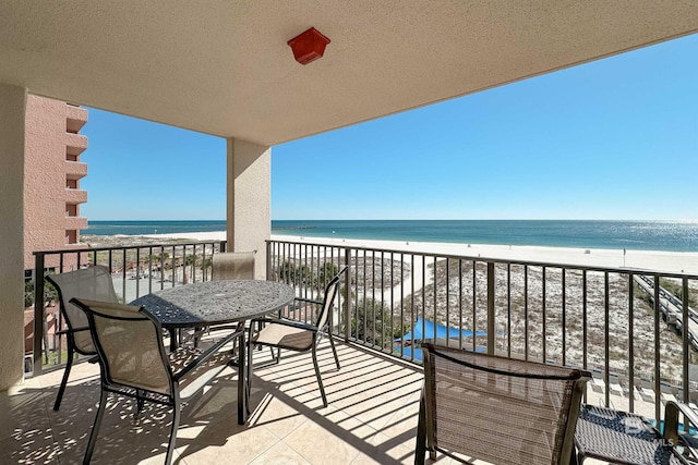 balcony with a beach view and a water view