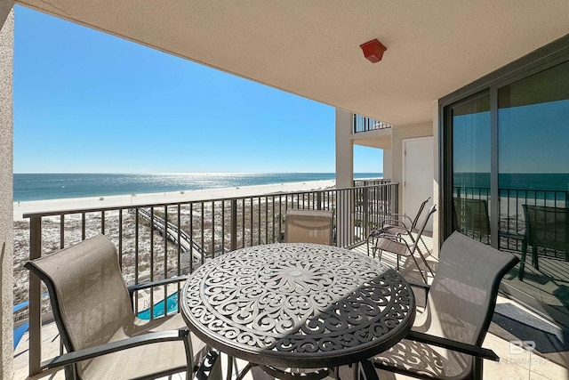 balcony featuring a water view and a view of the beach